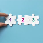 hand moving puzzle pieces with numbers 1 2 3