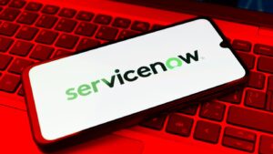 ServiceNow Logo on a smart phone on a laptop with a red light filter