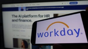 Workday Logo on smartphone with blurred image in background with the words, The AI platform for HR and Finance
