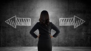 Business woman has to choose - looking at wall with two arrows