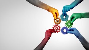 5 hands holding gears coming together as a business concept