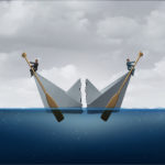 business people rowing in different direction in a split paper boat